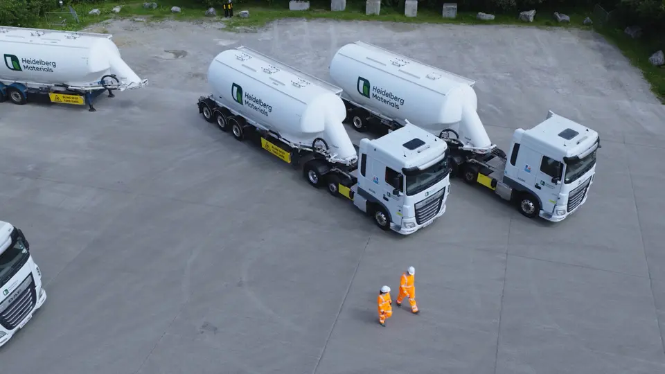 Drone of cement tankers with drivers walking